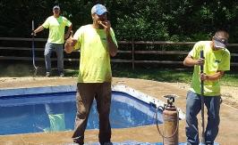 Eating some pizza while finishing concrete around a swimming pool!